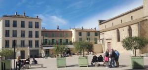 Un grupo de personas caminando por un patio. en Le Patio superbe T3 Climatisation Terrasse Wi-Fi Netflix 15 mn coeur de ville 70 m2, en Béziers