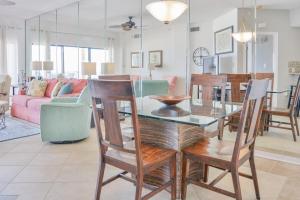 a dining room and living room with a table and chairs at The Palms 314 in Orange Beach