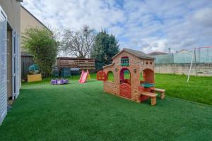 een tuin met een speelhuis en een speeltuin bij Maison spacieuse de 100m2 avec 3 chambres et jardin à 10 min à pied de la gare de meaux, 20 min de Disney et 30 min de paris in Villenoy