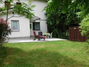 uma casa com uma cadeira vermelha e uma mesa num quintal em Appartement mit Garten em Werneuchen
