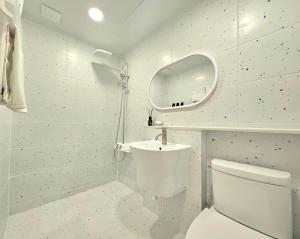 La salle de bains blanche est pourvue de toilettes et d'un lavabo. dans l'établissement Hotel Jeong Ansan Seonbu, à Ansan
