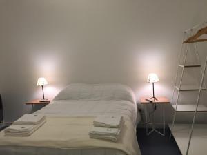 a bedroom with a bed and two lamps on two tables at Ukurj Apartamentos in Ushuaia