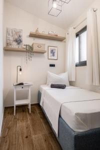 two beds in a room with a table and a desk at the train studio in Jerusalem