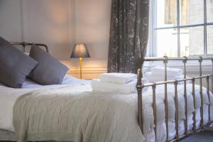 バースにあるThe Georgian Townhouse @ Pierrepont Placeの白いシーツと窓のあるベッドのある寝室