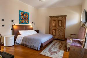 ein Schlafzimmer mit einem Bett und einem Wandgemälde in der Unterkunft Residenza San Flaviano, Relais di Charme in LʼAquila