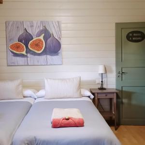 ein Schlafzimmer mit zwei Betten und einem Bild von Früchten in der Unterkunft Cabaña Rural ¨La Huerta de los Serijos¨ in Fuente el Fresno