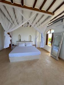 sypialnia z dużym białym łóżkiem i lustrem w obiekcie Sea view house w mieście Kilifi