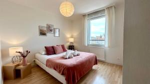 a bedroom with a bed with a red blanket and a window at Pointe de Sel, appartement face au port du Crotoy in Le Crotoy