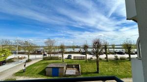 a view of a park with trees and a street at Pointe de Sel, appartement face au port du Crotoy in Le Crotoy +4 photos