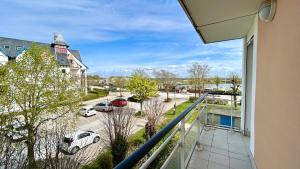 a balcony with cars parked in a parking lot at Pointe de Sel, appartement face au port du Crotoy in Le Crotoy