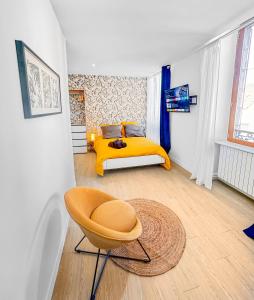 sypialnia z żółtym łóżkiem i krzesłem w obiekcie Le Victor Hugo & son Jardin - Détente à Montluçon w mieście Montluçon