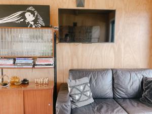 un sofá de cuero en una sala de estar con espejo en Retro Style Beach Retreat - Matarangi Holiday Unit, en Matarangi