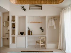 Cette chambre blanche dispose d'une chaise et d'un bureau. dans l'établissement Hotel Rural Morvedra Nou, à Ciutadella