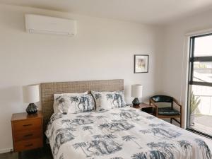 1 dormitorio con cama y ventana en Retro Style Beach Retreat - Matarangi Holiday Unit, en Matarangi