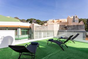 patio z krzesłami ogrodowymi i budynek w obiekcie Sunny island atico cruz w mieście San Andrés