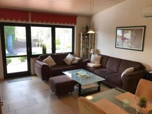 布特亚丁根E13 Ferienhaus mit Garten, Terrasse und Deichblick的客厅里有一张沙发和一张桌子。