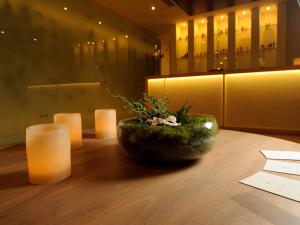 a table with candles and a vase with flowers on it at NOI Vitacura in Santiago