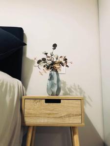 a vase of flowers on a table next to a bed at Eden Condo Athens in Athens