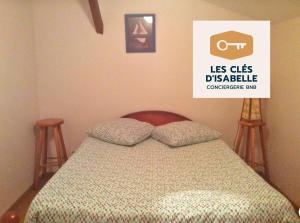 ein Bett mit zwei Kissen in einem Schlafzimmer mit einem Schild in der Unterkunft Maison entière feytiat in Feytiat