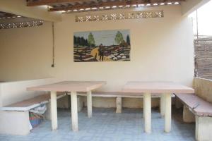 two tables in a room with a painting on the wall at Moyite Gandiol in Ndiébène