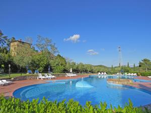 a large swimming pool with white chairs in a park at Il Doccino in Riparbella