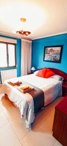 Precioso apartamento renovado en Avilés في أفيليس: غرفة نوم بسرير كبير بجدران زرقاء