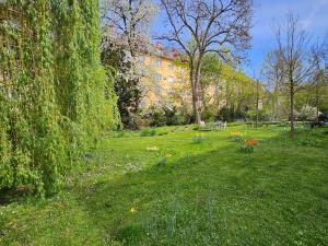 un patio de césped con un banco y flores en un parque en Yellow Flat by GrazRentals with best location & free parking en Graz