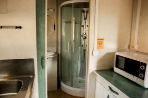 a small kitchen with a shower and a microwave at Camping Castillo de Loarre in Loarre +133 photos