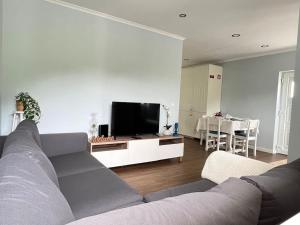 a living room with a couch and a flat screen tv at Casa Santa Rita in Alcobaça
