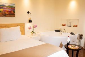 Hotel Cipriani في تارما: غرفة نوم مع سرير وحوض استحمام