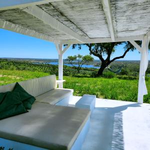 un canapé blanc sous une pergola avec un arbre dans l'établissement MONTE DA FIFAS Alentejo, Montargil, à Montargil