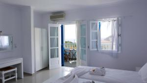 biała sypialnia z łóżkiem i kominkiem w obiekcie Limnionas Bay Village Hotel w mieście Marathokampos