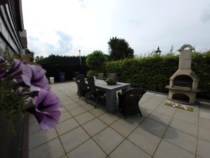 patio ze stołem, krzesłami i kominkiem w obiekcie B&B Buutegeweun w mieście Sommelsdijk