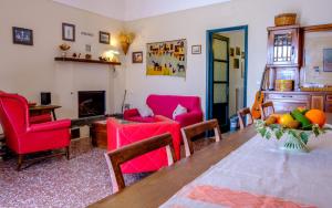 sala de estar con mesa, sillas y chimenea en L'uva e il vento - Convivial Farmhouse, en Ragalna