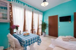 ein blaues Wohnzimmer mit einem Tisch und Stühlen in der Unterkunft Tiny house with a pool in Athen