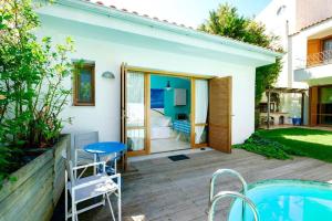 eine Terrasse mit einem Tisch, Stühlen und einem Pool in der Unterkunft Tiny house with a pool in Athen