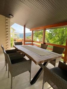 una mesa de madera y sillas en un porche con vistas en El Mar House en Petrovac na Moru