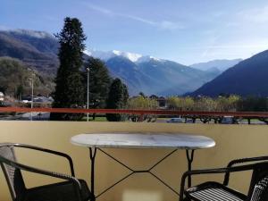 d'une table et de deux chaises sur un balcon avec vue sur les montagnes. dans l'établissement Le Chasseur Alpin, à Albertville