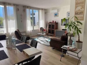 un salon avec une table et des chaises et un salon dans l'établissement Le Chasseur Alpin, à Albertville