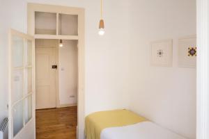 a white bedroom with a bed and a hallway at Apartment in Lisbon city center with a terrace, 317 in Lisbon