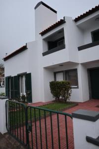 a white building with a fence in front of it at Wild Blue By SVL in Ponta Delgada