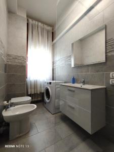 y baño con lavamanos y lavadora. en Casa Aris Fiera Vicenza, en Vicenza