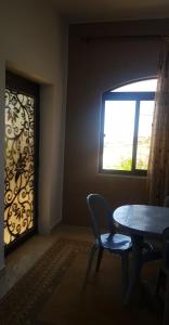 een eetkamer met een tafel en een raam bij Golden hotel in Jerash
