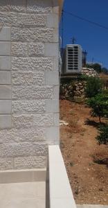 a white brick wall with an air conditioner on a building at Golden hotel in Jerash