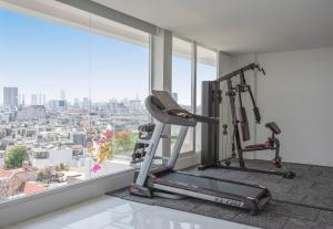 a gym with a view of a city at M Village Nguyễn Kiệm - Cosmo Airport Hotel in Ho Chi Minh City