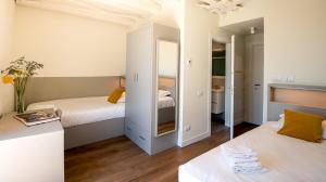 een kleine slaapkamer met 2 bedden en een spiegel bij Il Santo Stays in Florence