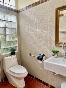 a bathroom with a toilet and a sink and a mirror at The Rain tree, Pool villa Pattaya in Pattaya Central
