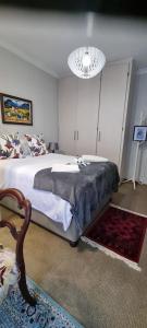 ein Schlafzimmer mit einem großen Bett und einem Kronleuchter in der Unterkunft VillaBell in Senekal