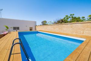 una piscina con terrazza in legno e muro di mattoni di Villa Adele con Piscina Privata - Torre San Giovanni a Torre San Giovanni Ugento