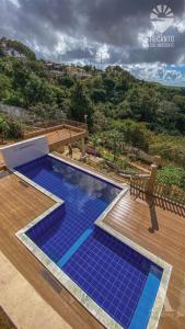 una piscina con azulejos azules en una terraza de madera en Pousada Recanto Sol Nascente, luxo e proximidade com a natureza en Rio Formoso